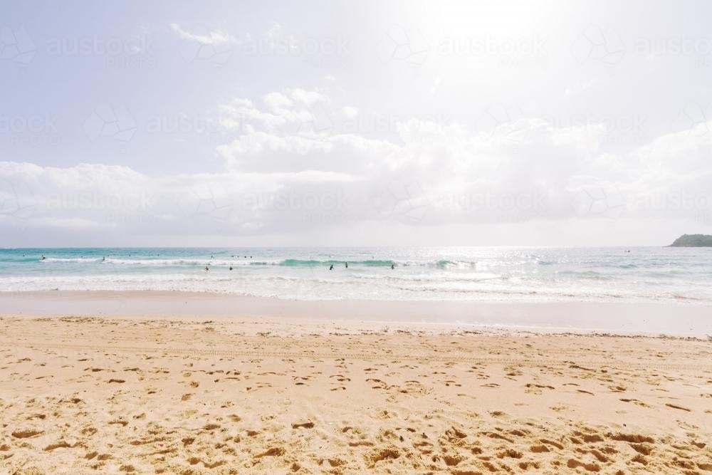 Walked in sand on Bondi Beach and surf with sun flare - Australian Stock Image
