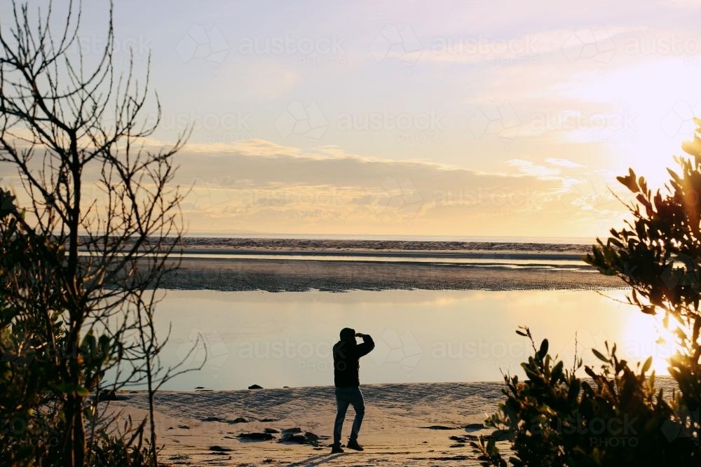 Walking along a beach at sunrise - Australian Stock Image
