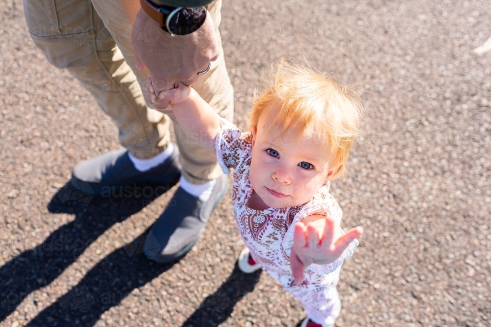 walking baby reaching out hand to hold to walk together - hold my hand and walk with me - Australian Stock Image