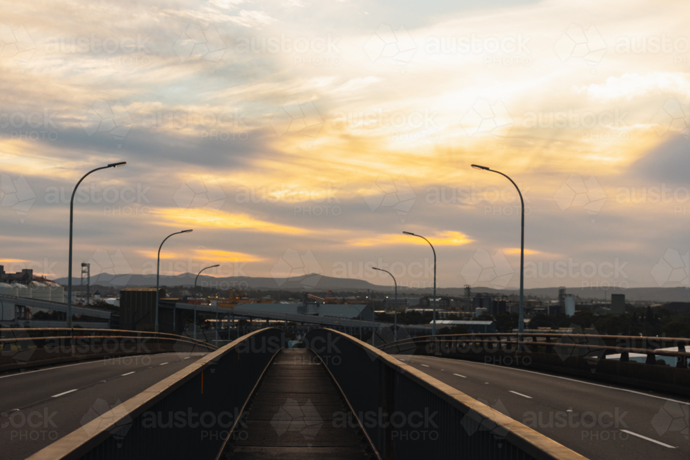 Walkway across top of Stockton Bridge with Newcastle industrial area in background - Australian Stock Image