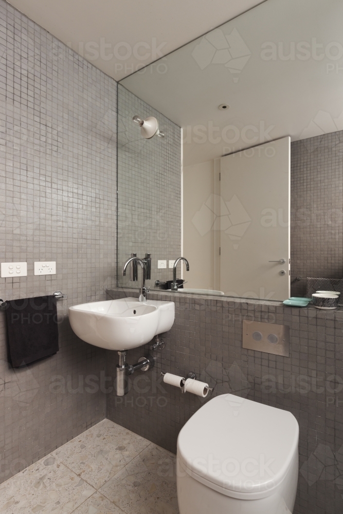 Wall mounted basin vanity in fully tiled mosaic modern bathroom - Australian Stock Image