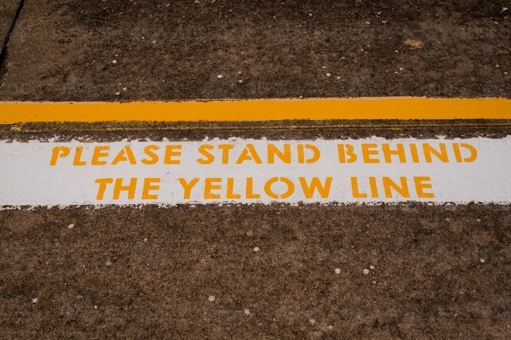 Image of warning sign to 'Please stand behind the yellow line' at ...