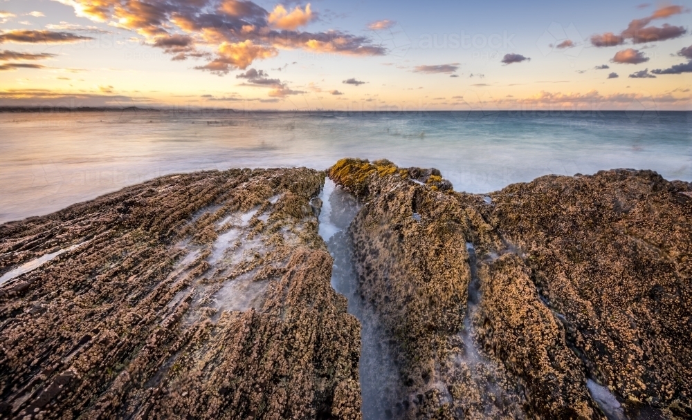 Water crashing over rocks at sunset - Australian Stock Image