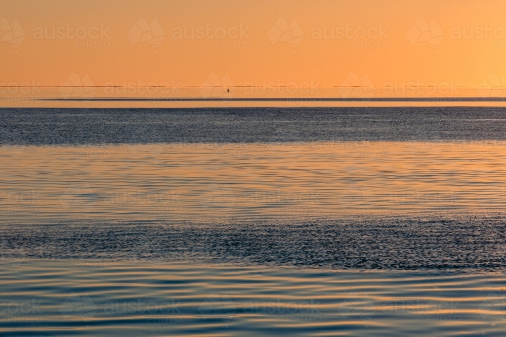 Water patterns on the calm ocean at sunset - Australian Stock Image