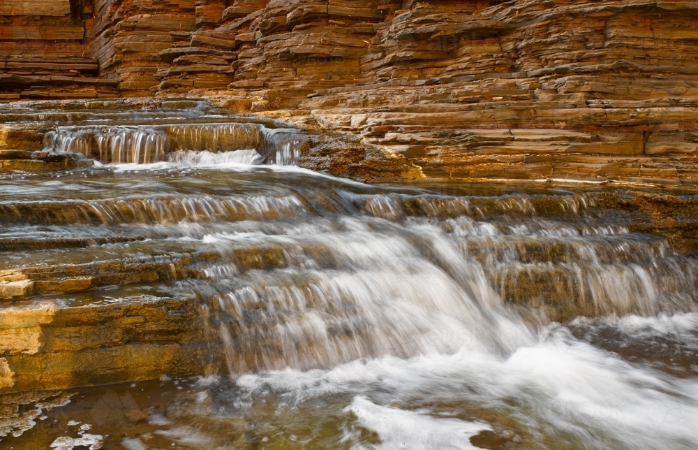 Waterfall flowing over rocks in national park - Australian Stock Image