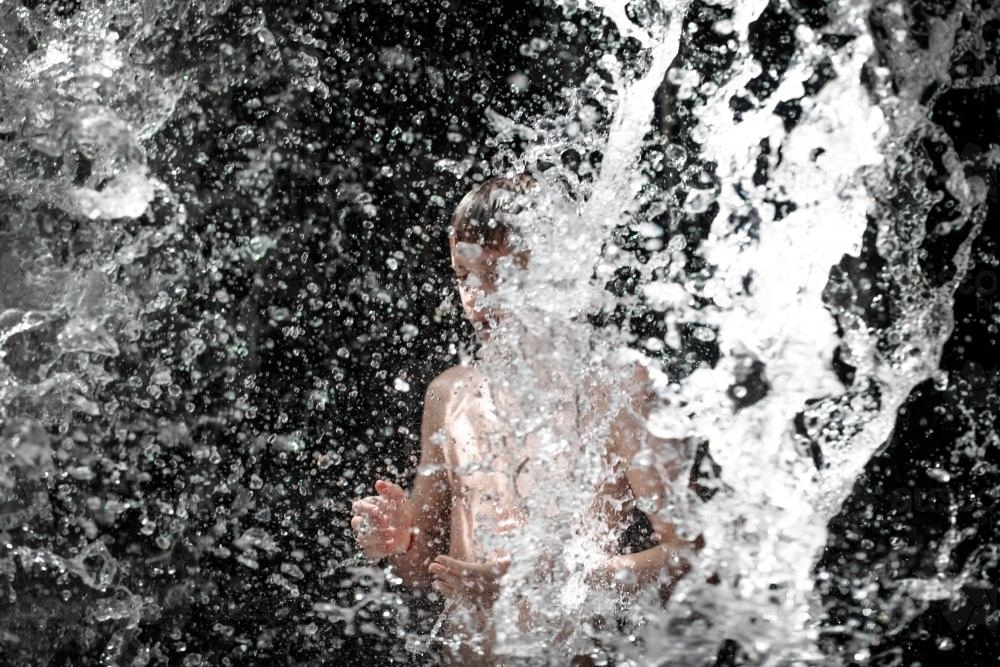Waterfall spashing boy - Australian Stock Image