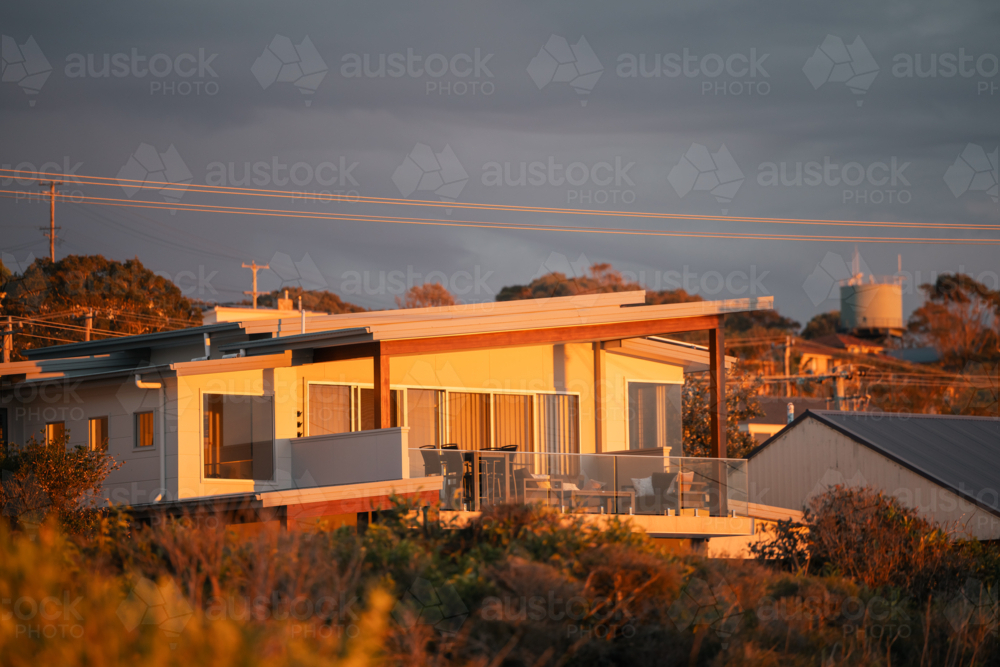 Waterfront home bathed in morning sunshine in coastal New South Wales suburb - Australian Stock Image
