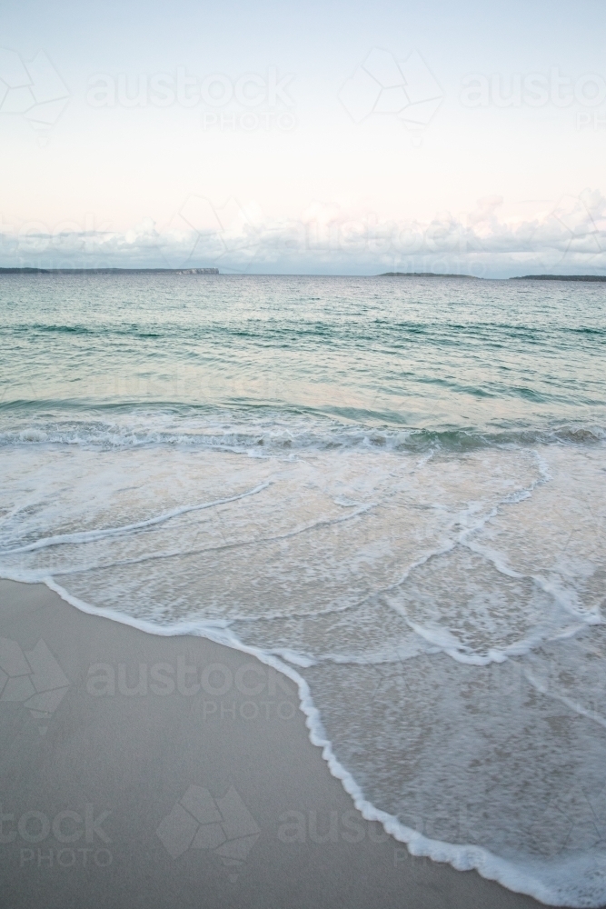 Waves and sea foam flowing against the shore - Australian Stock Image