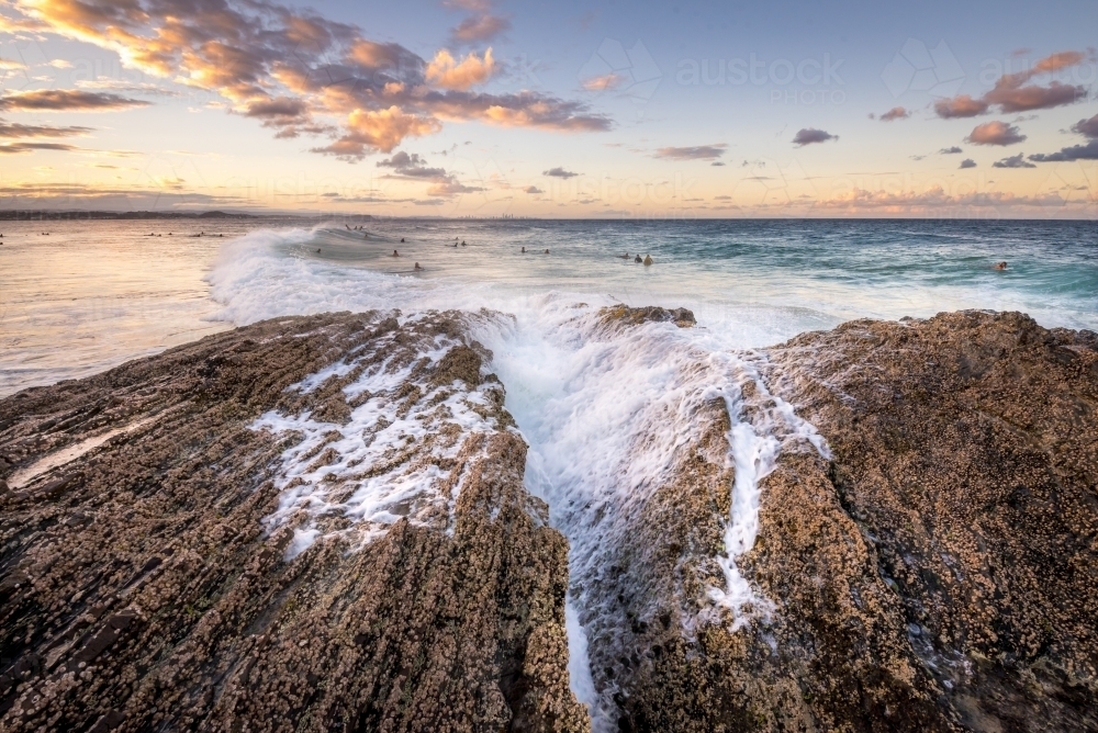 Waves breaking over rocks at the beach - Australian Stock Image