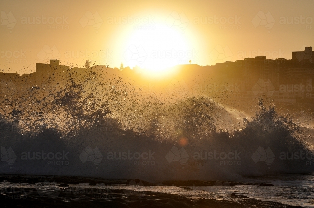 Waves crashing against the sun - Australian Stock Image