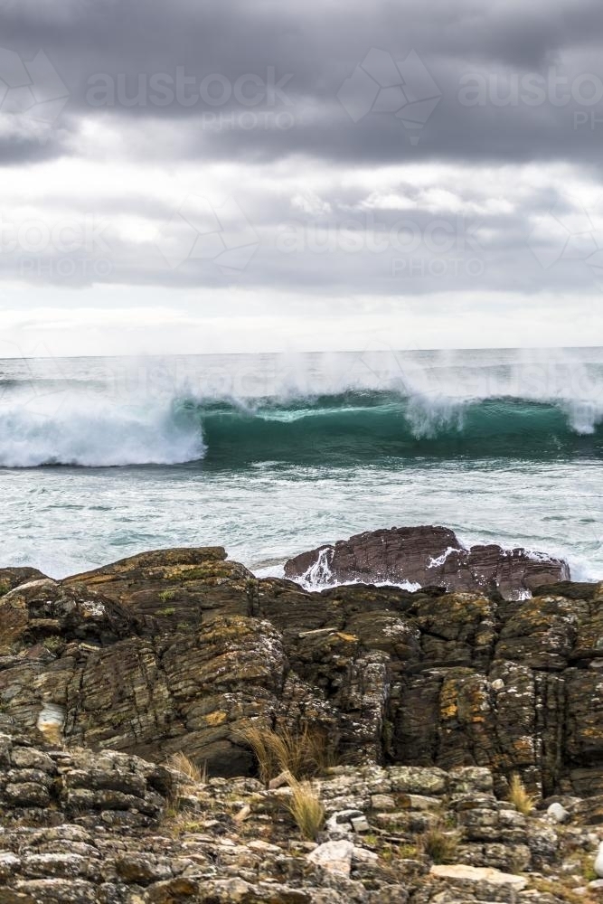 Waves crashing into the rocky coastline - Australian Stock Image