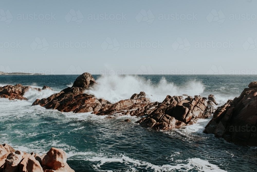 Waves crashing on rock formations just off coastline - Australian Stock Image