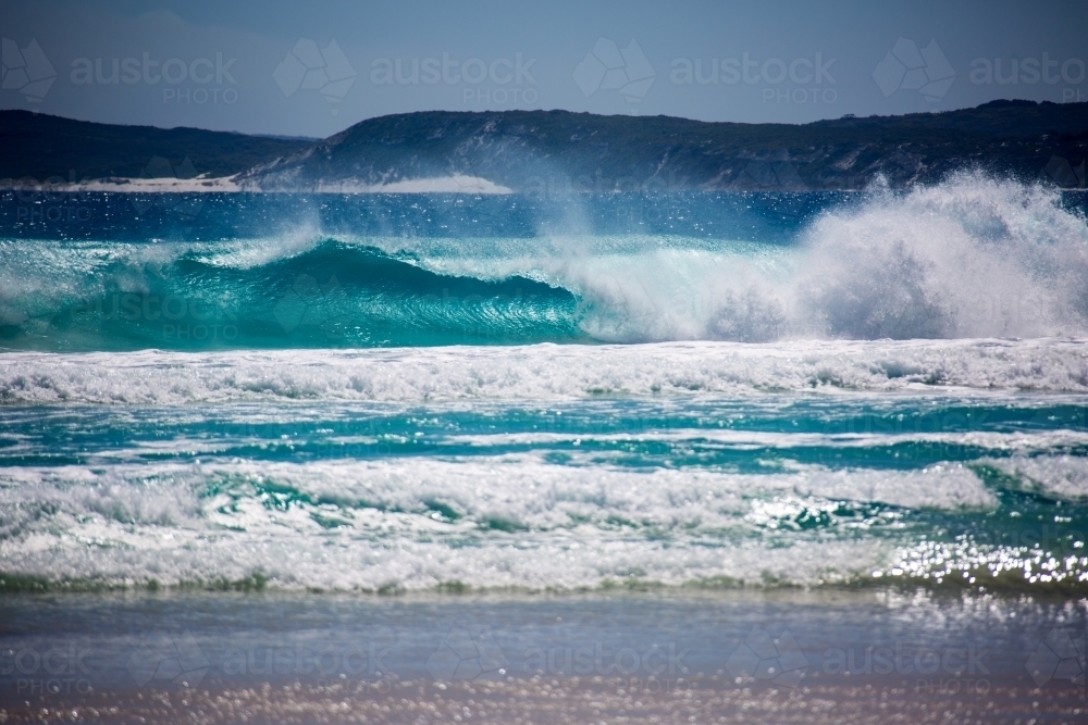 Waves crashing onto a beach with turquoise water - Australian Stock Image