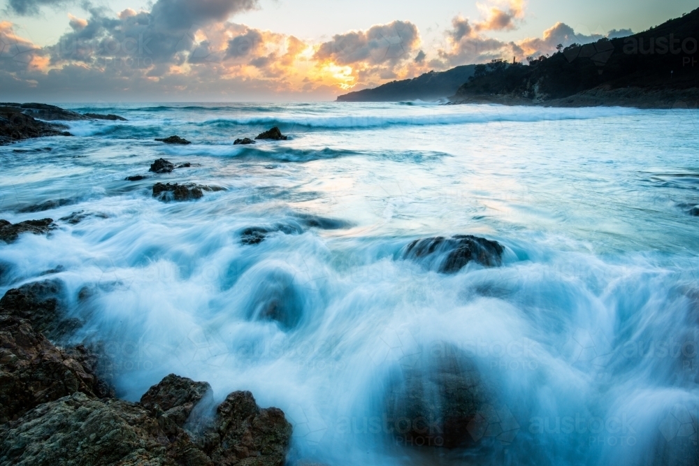 Waves crashing over rocks at Honeymoon Bay at Moreton Island - Australian Stock Image