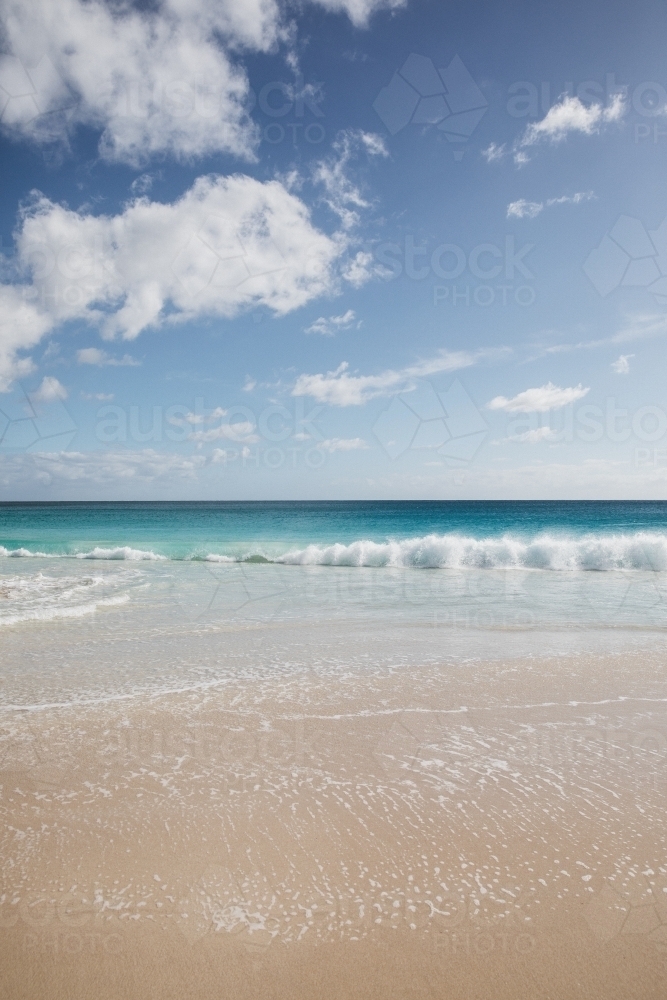 Waves on empty beach in morning light - Australian Stock Image