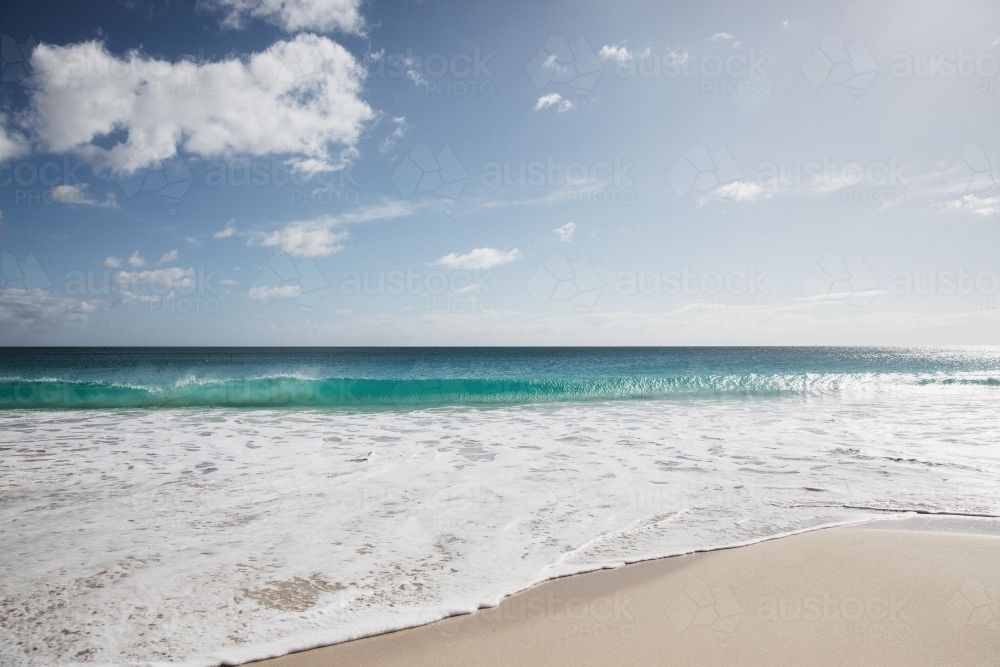 Waves on empty beach in morning light - Australian Stock Image