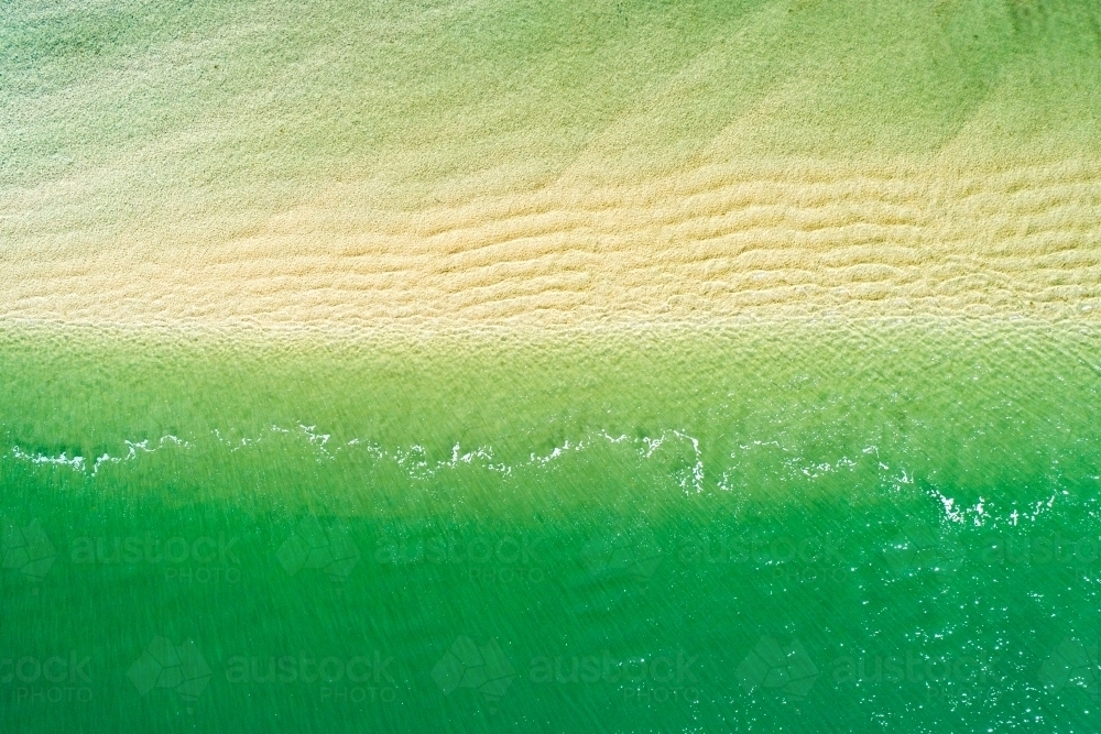 Waves rippling over sandbar. - Australian Stock Image