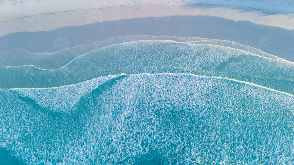 Waves rolling onto the sandy shoreline - Australian Stock Image