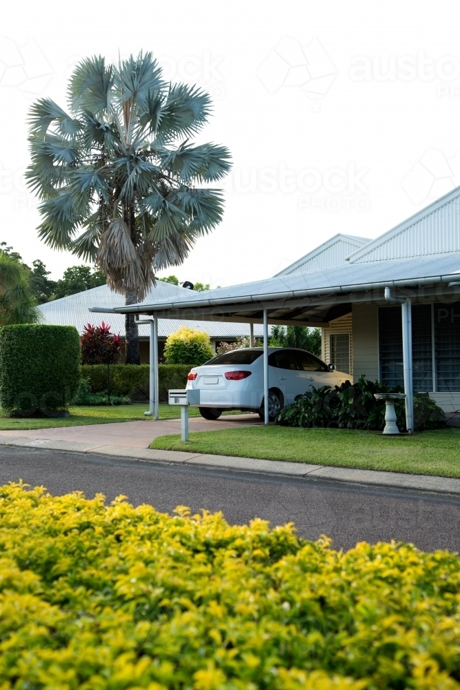 Weatherboard home in a picturesque street with hedge in the middle of the road - Australian Stock Image