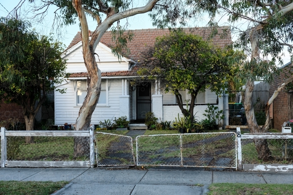 Weatherboard house with gum trees and old fence - Australian Stock Image