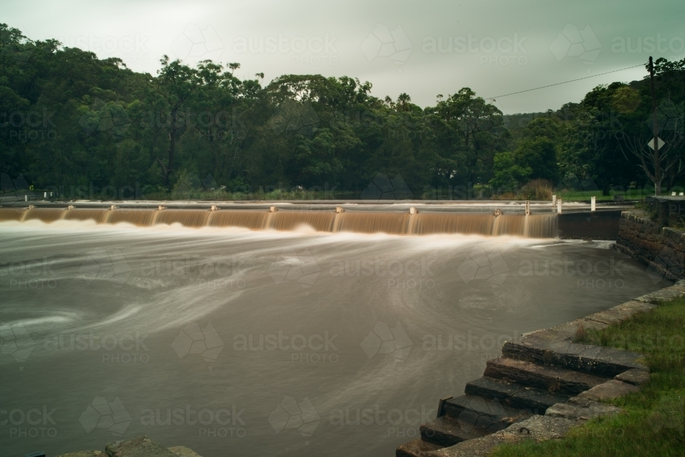 Weir and river in flood - Australian Stock Image