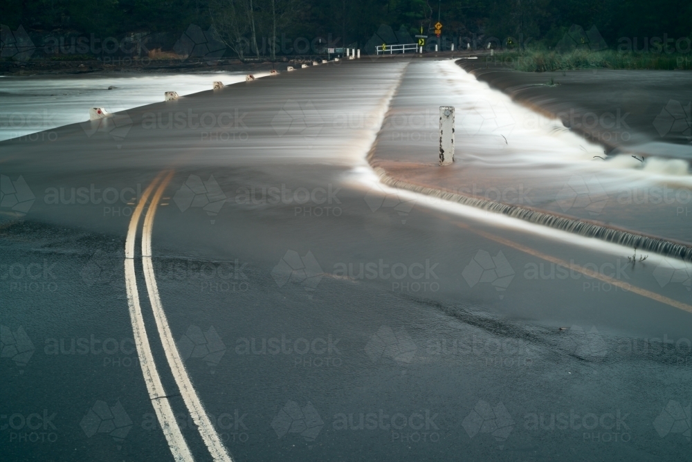 Weir in flood over road - Australian Stock Image