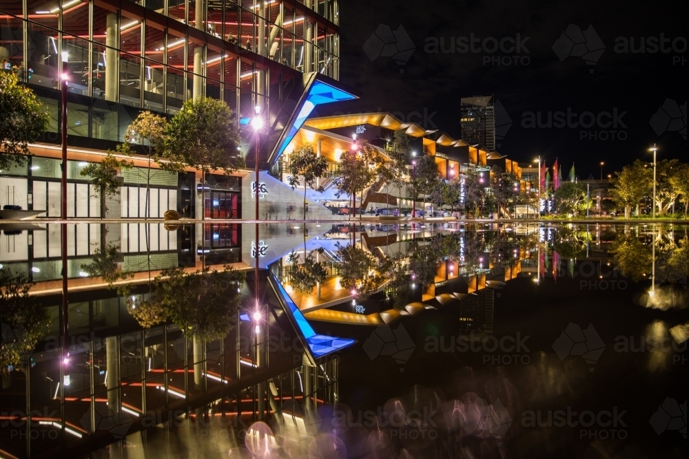 Wet pavement reflection of the new International Convention Centre Sydney illuminated at night - Australian Stock Image
