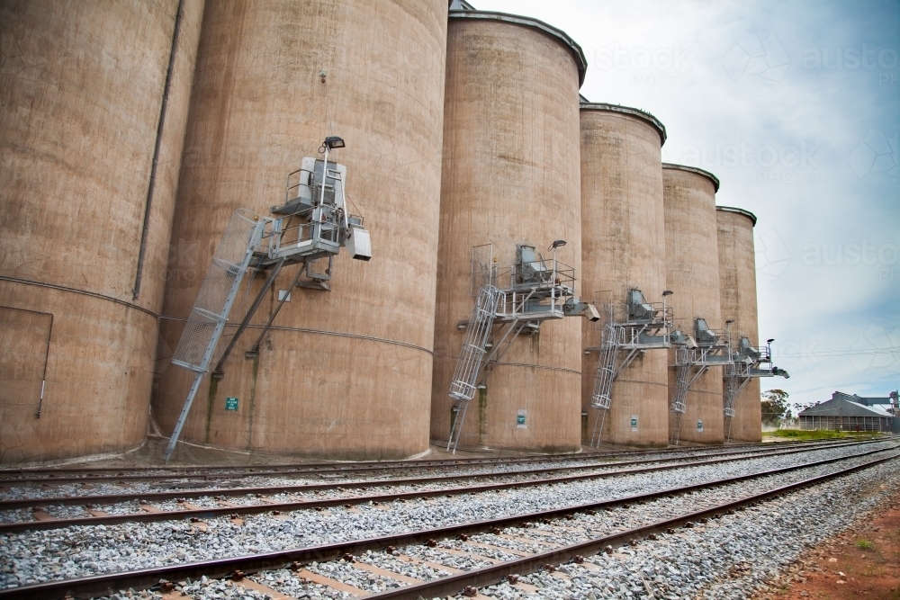 Wheat silo infrastructure beside a train line on an overcast day - Australian Stock Image