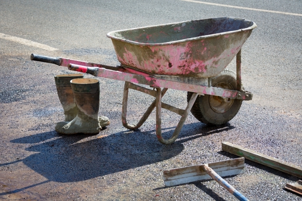 Wheelbarrow, tools and boots of concrete worker - Australian Stock Image