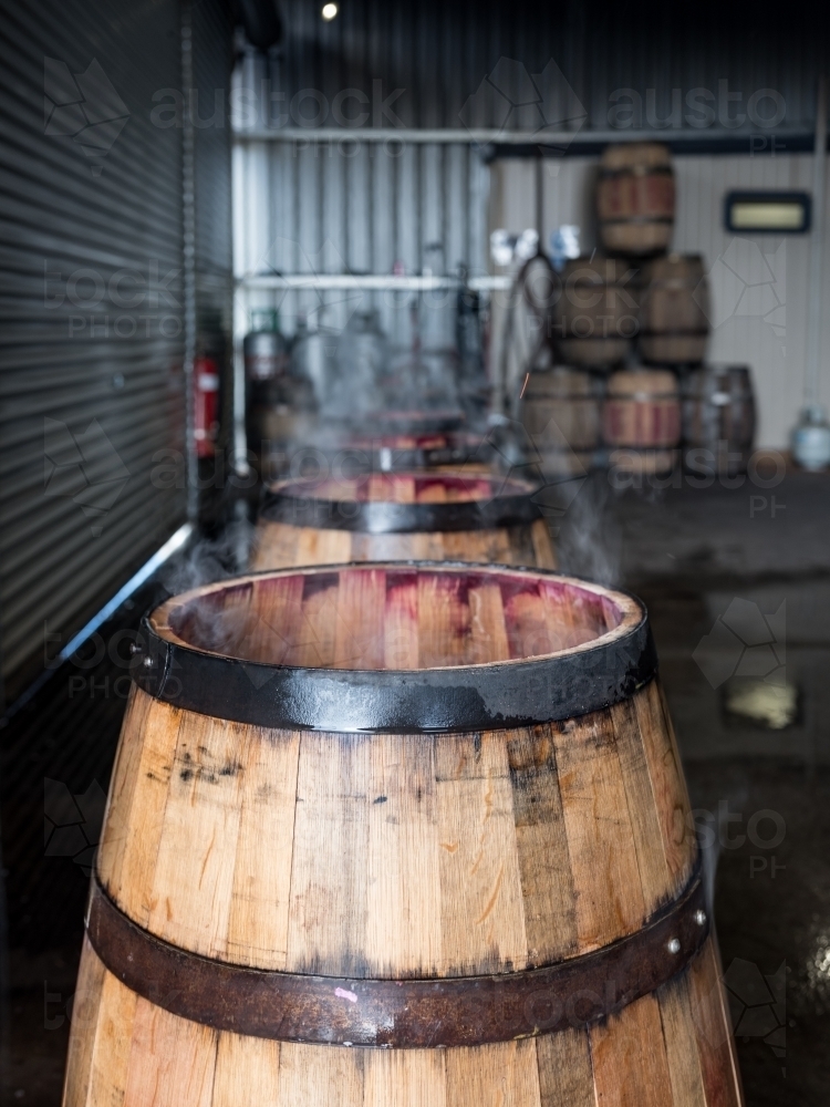 Whisky barrels are lined up while being charred for storage - Australian Stock Image