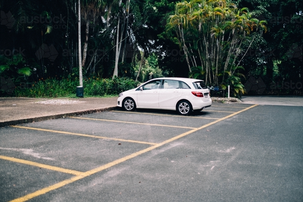 White car parked in empty car park - Australian Stock Image