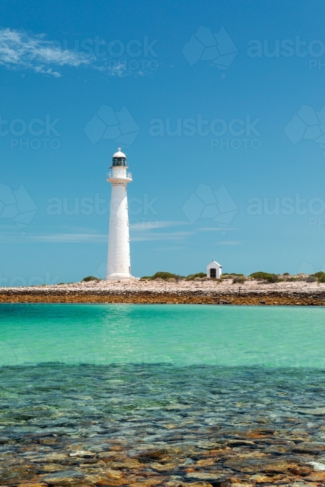 white lighthouse with blue sky and turquoise shallow water - Australian Stock Image