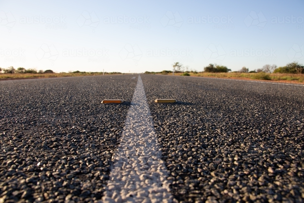 White line and cats-eye reflectors on an outback highway - Australian Stock Image