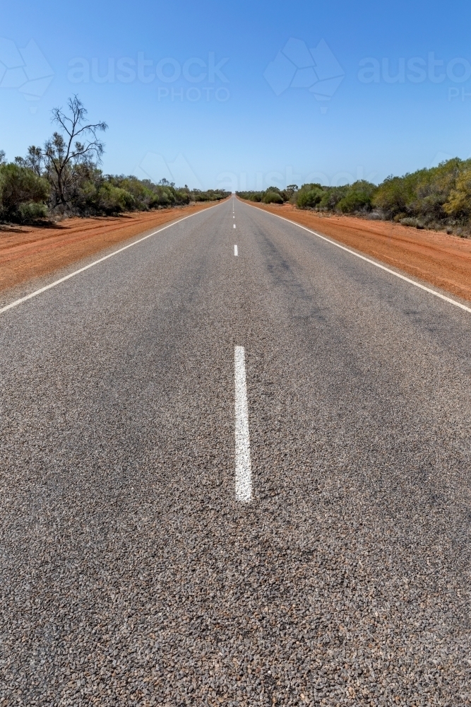 White line down middle of long, empty, straight road in rural Western Australia - Australian Stock Image