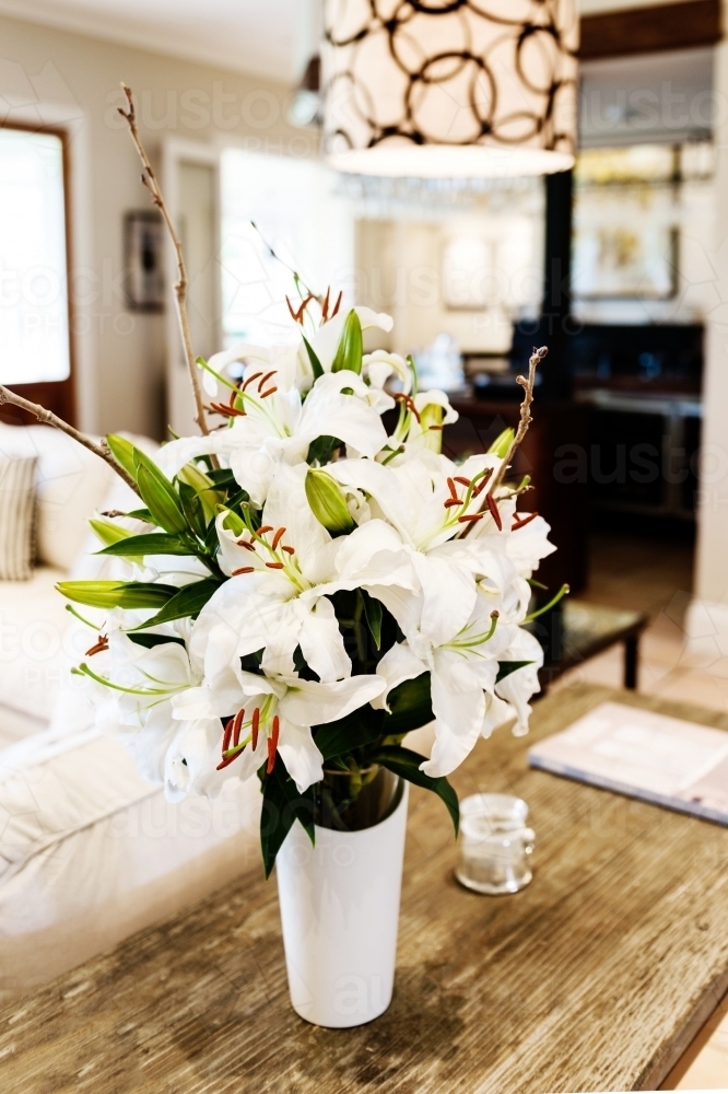 white oriental lillies on a table - Australian Stock Image