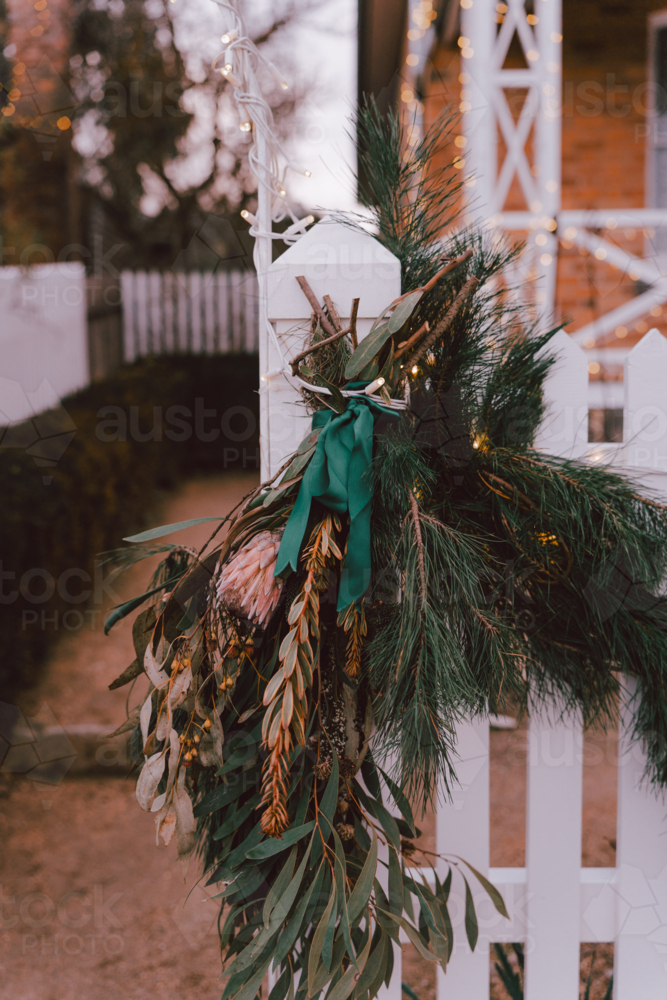 White picket fence decorated with greenery and lights - Australian Stock Image