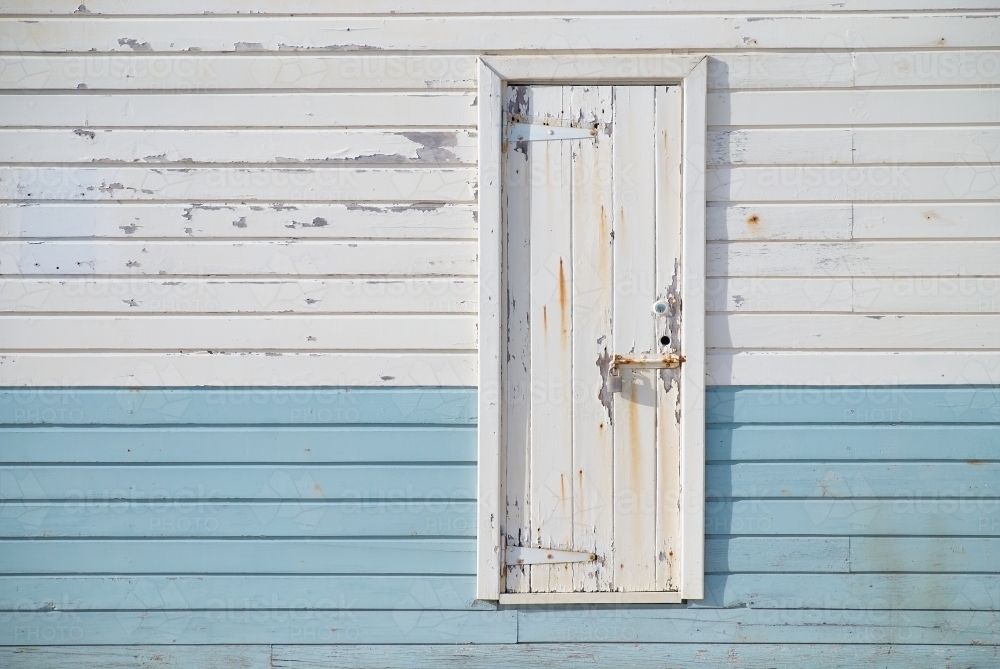 White rusting door on blue and white paneling on a port building. - Australian Stock Image