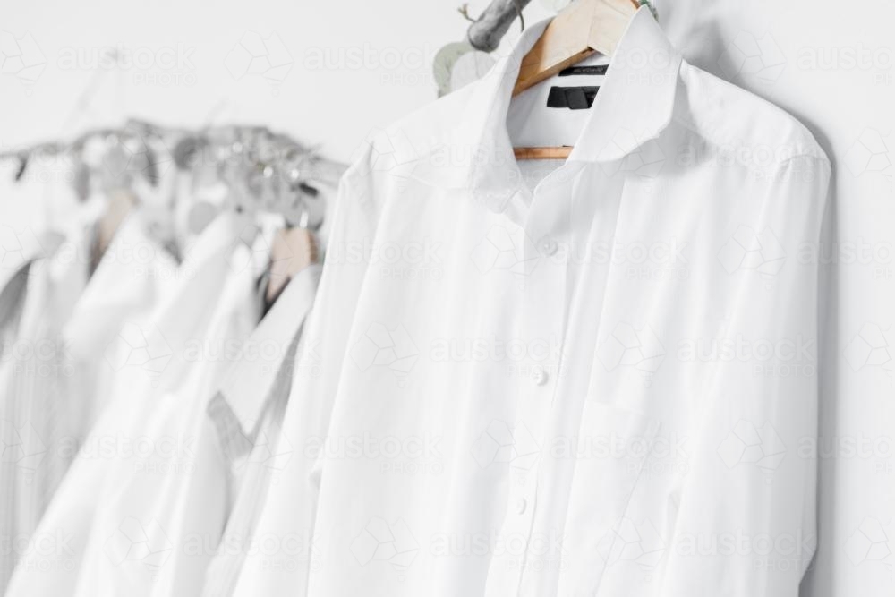 white shirts on a hanger, against a white background - Australian Stock Image