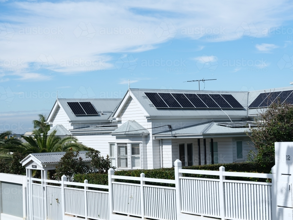 White single-story house with solar panels on the roof. - Australian Stock Image