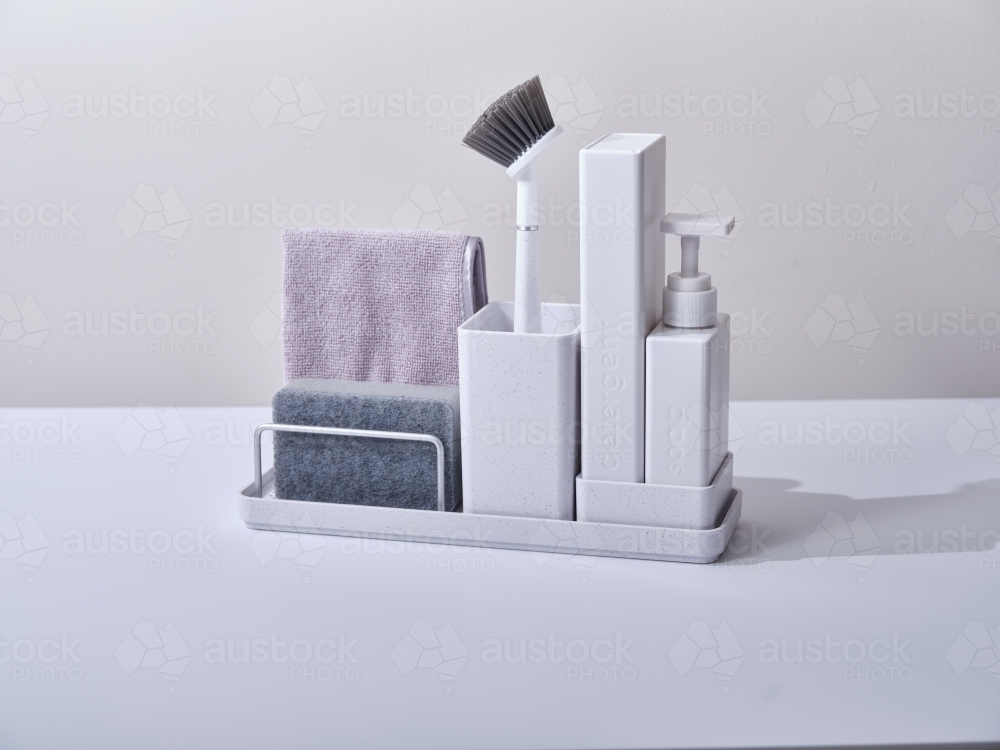 White sink organiser with toilet brush, sponge, and a towel - Australian Stock Image