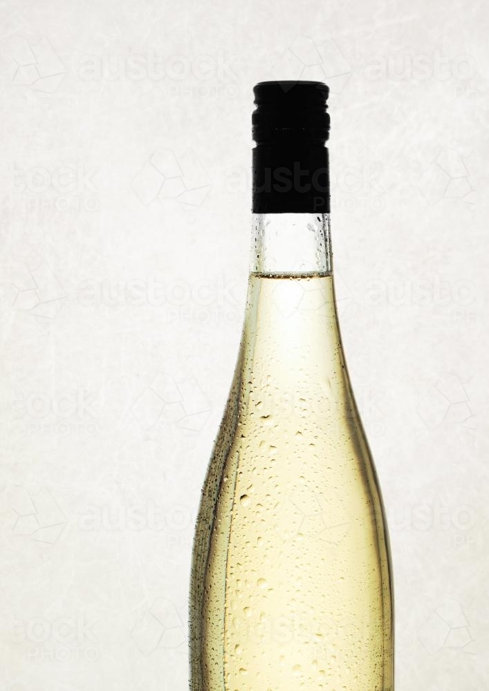white wine in a bottle with no label, against a plain background - Australian Stock Image