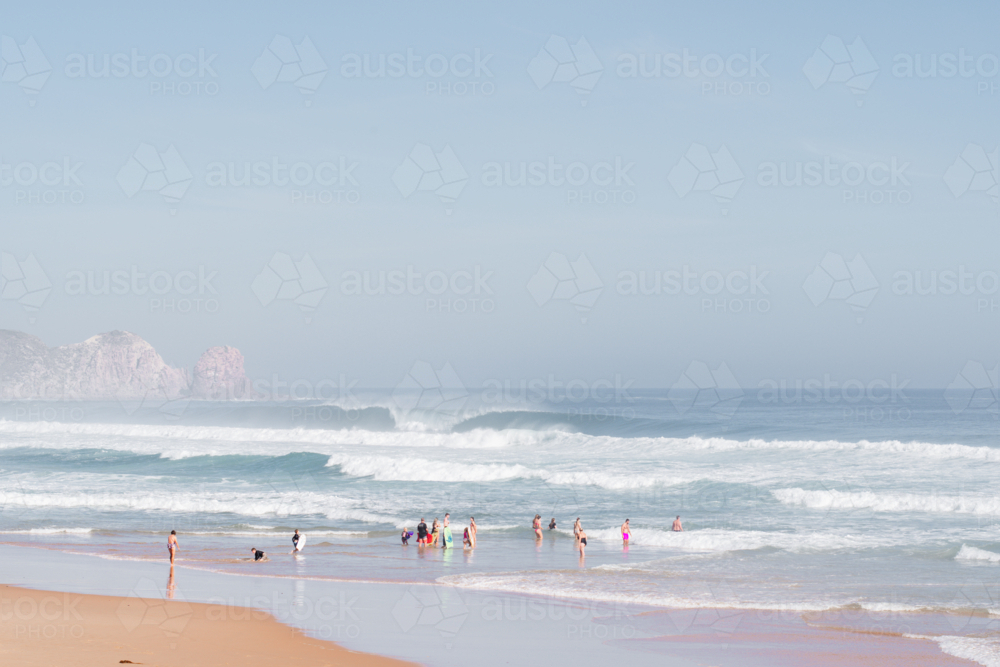 Wide shot of people in the wild surf at Cape Woolamai - Australian Stock Image