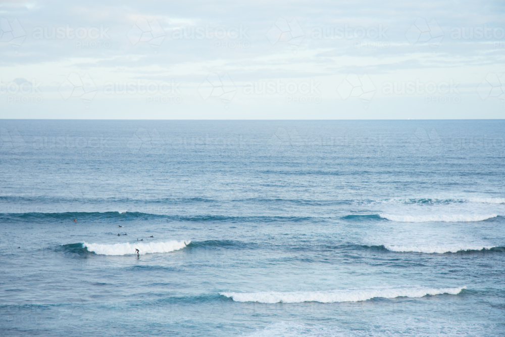 Wide shot of surfers catching waves on ocean break - Australian Stock Image