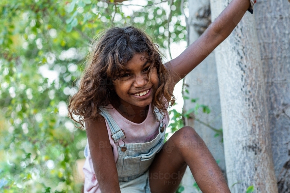 wild looking kid climbing in a tree - Australian Stock Image