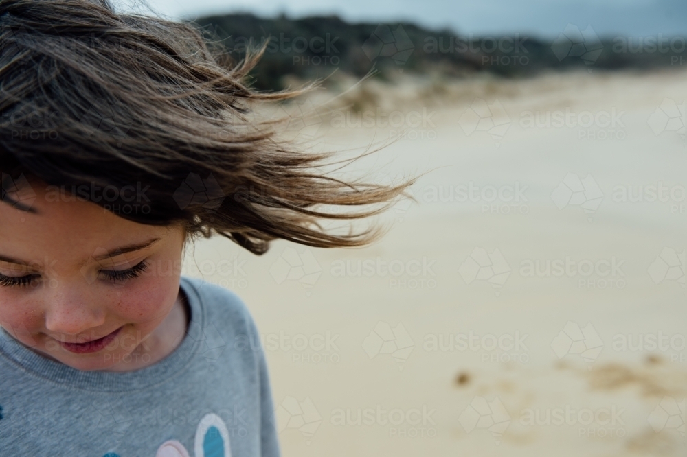 Wind blowing brunette girls hair - Australian Stock Image