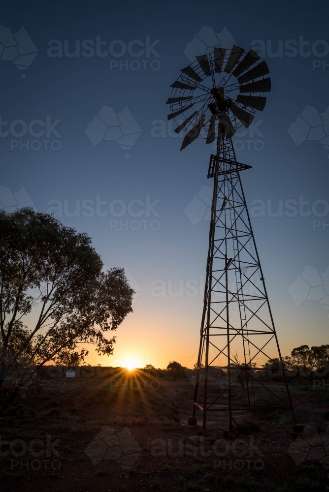 Wind mill silhouette at dusk in Australian outback - Australian Stock Image