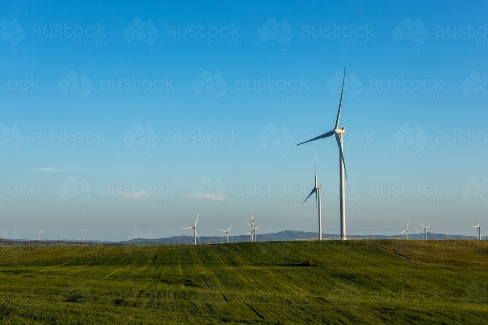 wind towers in late afternoon with farmland in foreground - Australian Stock Image