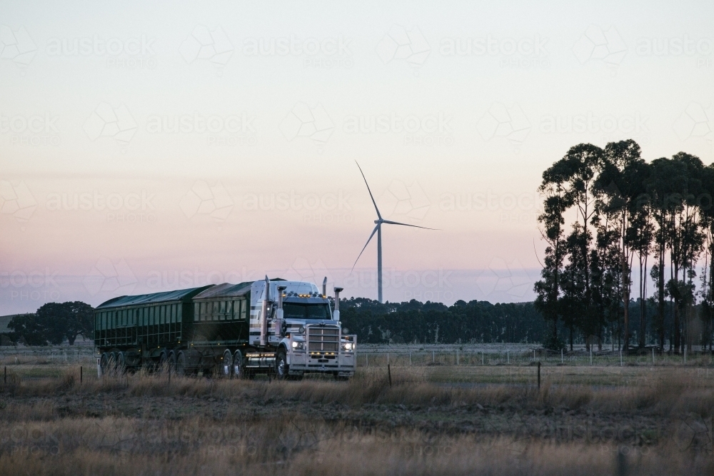 Wind turbine in the countryside on dusk with Semi Trailer transport foreground details - Australian Stock Image