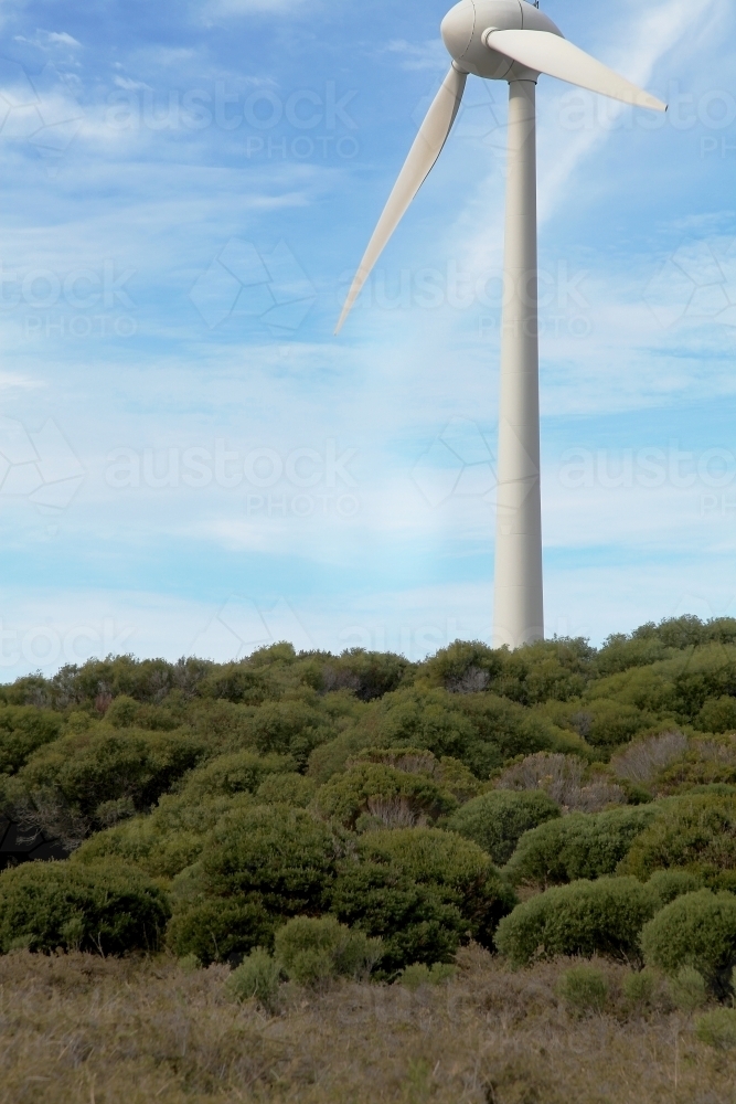 Wind turbine on mountain above low lying shrubs - Australian Stock Image