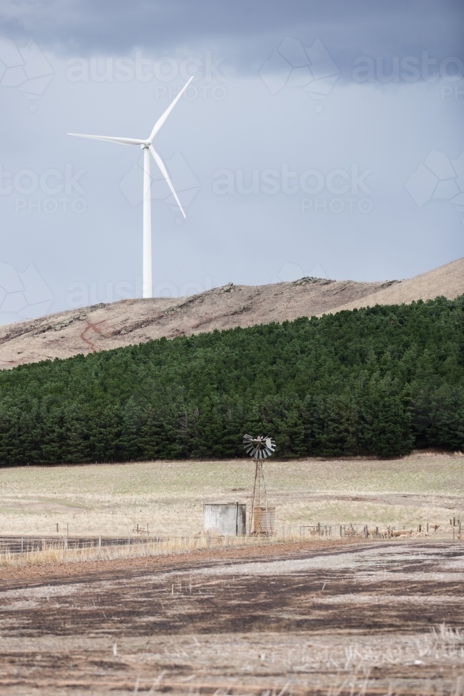 Wind turbine with windmill and water tank in foreground - Australian Stock Image